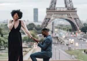 A man proposes to a woman in front of the Eiffel Tower.