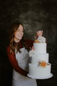 Maggie Banko holding one of her wedding cakes.